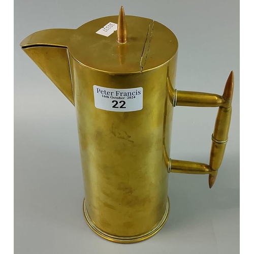 22 - A brass hot water jug in the style of Christopher Dresser, formed from a military shell case. Probab... 