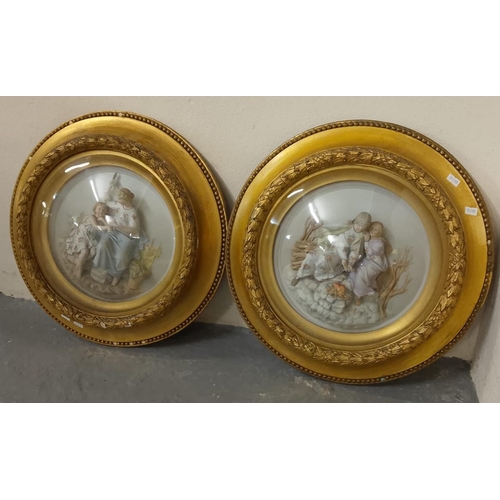 431 - Pair of Continental porcelain relief figural panels in circular gilded frames under convex glass. Ov... 