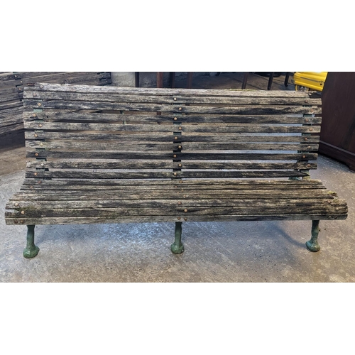 465 - Slatted wooden garden bench with three part cast iron underframe. 182cm wide approx. (B.P. 21% + VAT... 