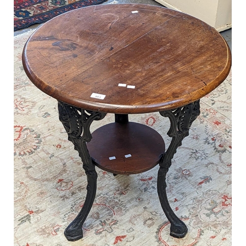 483 - Heavy cast iron pub type table with pierced cabriole legs and circular hardwood top and under-tier. ... 