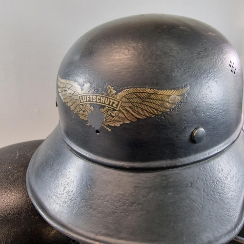 320 - Four German helmets to include: Two German Luftschutz M38 'Gladiator' helmets, one with liner. One G... 