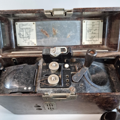 63 - German Bakelite field telephone with steel catch and applied instruction labels. 27.5cm wide approx.... 