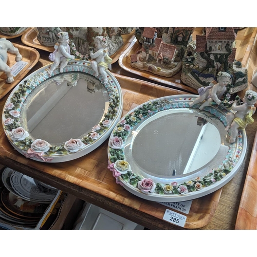 285 - A pair of German Sitzendorf easel porcelain dressing table mirrors, overall with mounted cherubs and... 