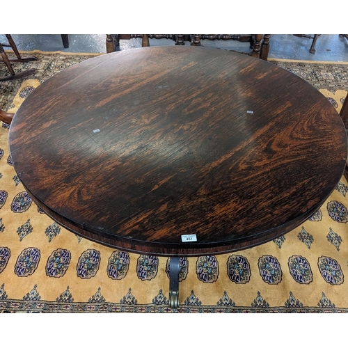 451 - Regency rosewood centre table on four out swept legs, brass paws and casters. 120cm diameter approx.... 