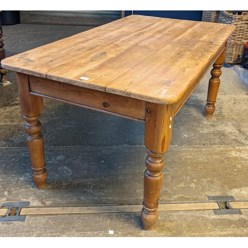 471 - Pine scrub-top kitchen table on baluster turned tapering legs. 150 x 85 x 77cm high approx. (B.P. 21... 