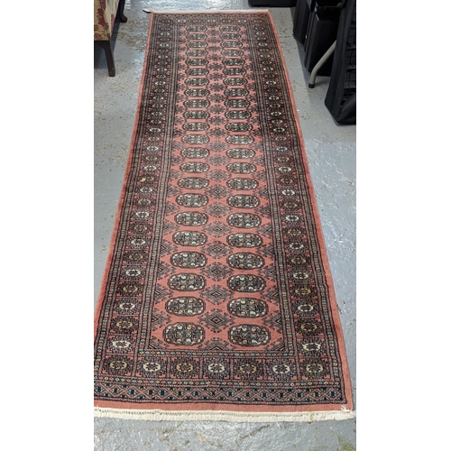 493 - Pakistan Bokhara red ground geometric runner. 250 x 80cm approx.  (B.P. 21% + VAT)