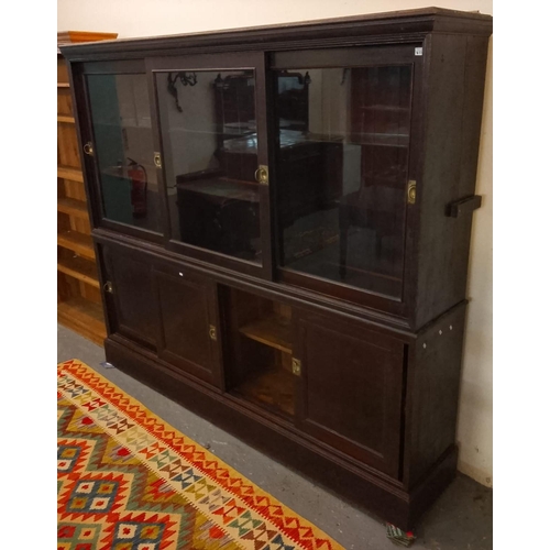 534 - Early 20th century stained pine shop cabinet, having moulded cornice above three glazed sliding door... 