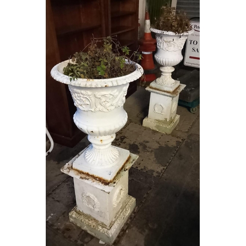 571 - Pair of cast metal campana shaped garden urns on cast iron square shaped wreath decorated pedestal b... 