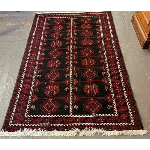 610 - Afghan red and black ground carpet with repeating geometric panels and stylised bird decoration. 205... 