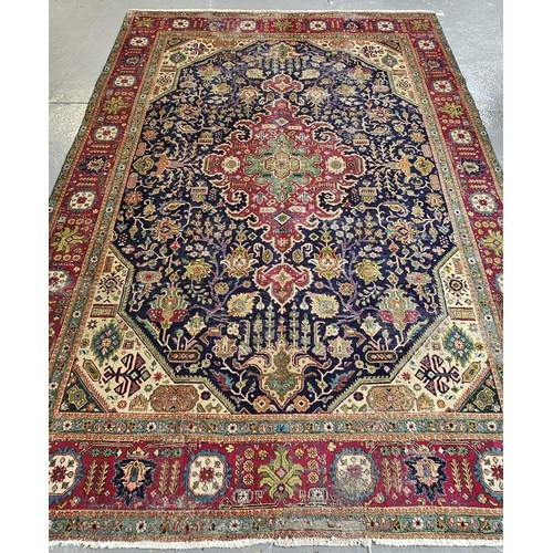 614 - Middle Eastern dark blue ground foliate carpet with repeating flowerhead borders. 340x242cm approx. ... 