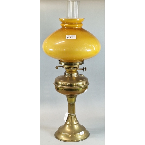 77 - Early 20th century double oil burner lamp having mustard glass shade on a brass base. (B.P. 21% + VA... 