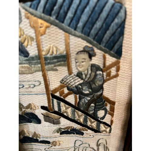 137 - A pair of Chinese needlepoint panels decorated with figures in landscapes and within pierced hardwoo... 