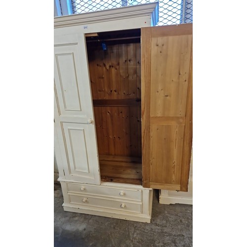 563 - Painted pine wardrobe with moulded cornice over two panelled doors with two drawers below. 102x58x19... 