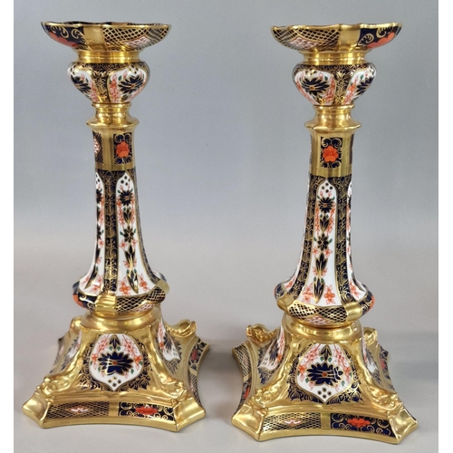 122 - Pair of Royal Crown Derby English bone china 1128 'Imari' candlesticks, on dolphin bases. 26.5cm hig... 