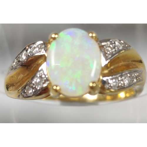 187 - 18ct gold diamond and opal ring, the central opal cabochon stone of oval form, flanked by tiny diamo... 