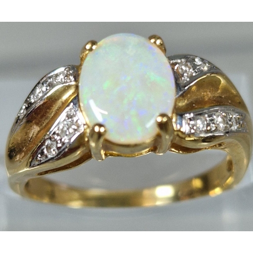 187 - 18ct gold diamond and opal ring, the central opal cabochon stone of oval form, flanked by tiny diamo... 