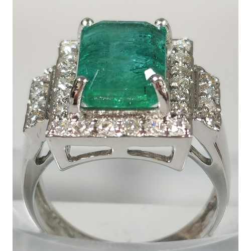 216 - 18ct white gold Art Deco style diamond and emerald ring, the central rectangular facetted emerald su... 