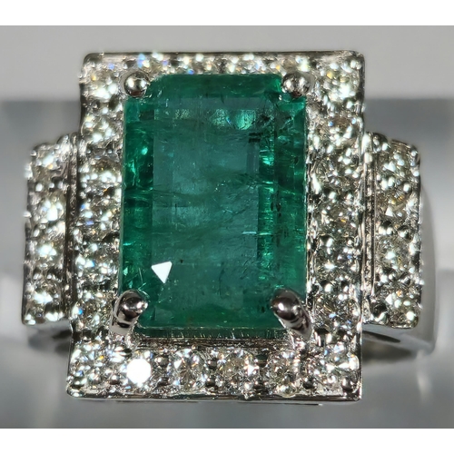 216 - 18ct white gold Art Deco style diamond and emerald ring, the central rectangular facetted emerald su... 