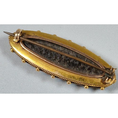 221 - Early Victorian yellow metal and black onyx mourning brooch, of oval form. 4.5cm long approx. in fit... 