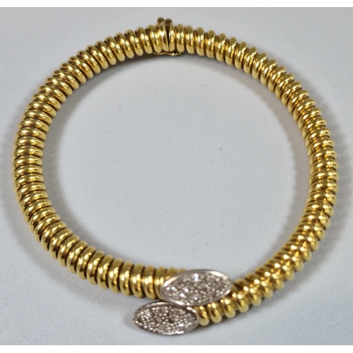 223 - Yellow metal spiral link hollow bracelet, with a crossover section at the front comprising two oval ... 