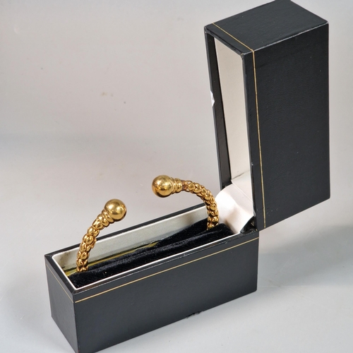 229 - 9ct gold ladies' torque bangle. In probably original box. 11.4g approx. (B.P. 21% + VAT)