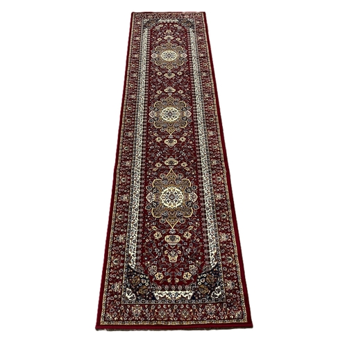 314 - Deep red ground full pile Turkish floral and foliate runner with central medallion designs. 299x80cm... 