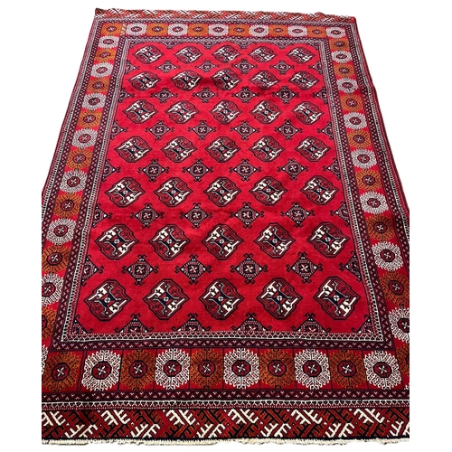 320 - Red ground woven Turkman carpet, all over with Bokhara designs. 295x200cm approx. (B.P. 21% + VAT)