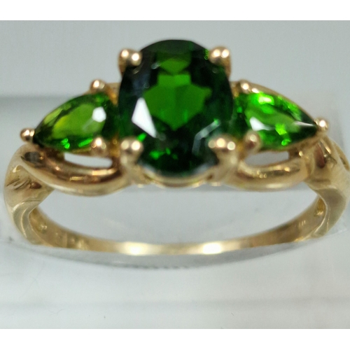 323 - 9ct gold green three stone dress ring. 2.3g approx. Size M1/2.  (B.P. 21% + VAT)