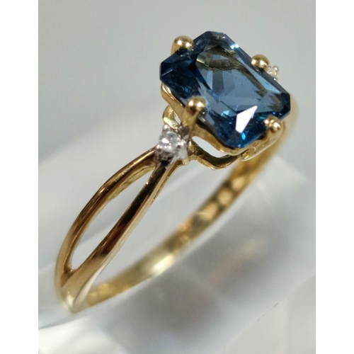 326 - 9ct gold and blue stone dress ring inset with two tiny diamond chips. 2g approx. Size R.  (B.P. 21% ... 