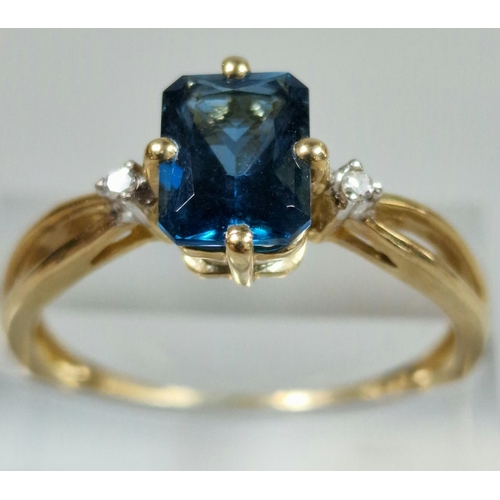 326 - 9ct gold and blue stone dress ring inset with two tiny diamond chips. 2g approx. Size R.  (B.P. 21% ... 