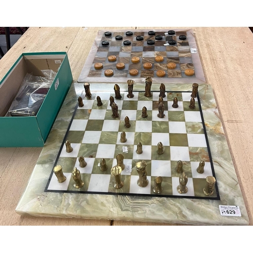 629 - Heavy brass chess set with onyx playing board, together with a droughts set on similar onyx playing ... 