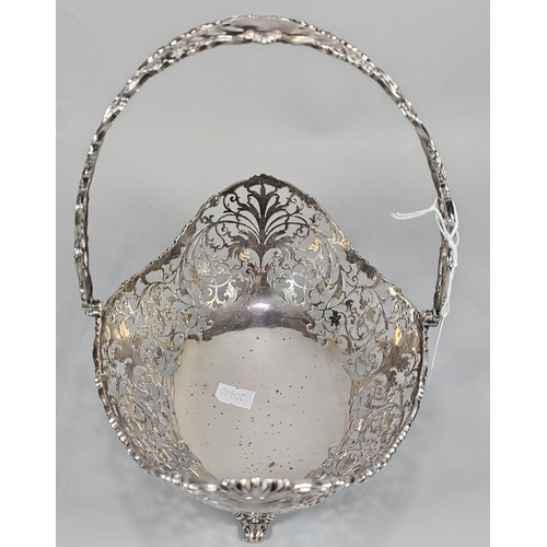 198 - George V silver ornate and pierced basket with swing loop handle on four repoussé scroll feet. By Jo... 