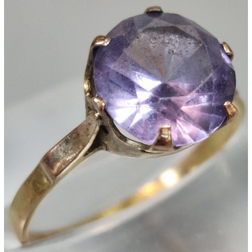 209 - 18ct gold dress ring inset with purple faceted stone. 1.9g approx. Size O. (B.P. 21% + VAT)