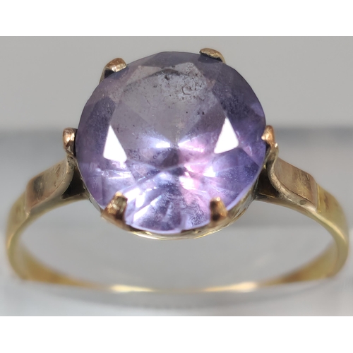 209 - 18ct gold dress ring inset with purple faceted stone. 1.9g approx. Size O. (B.P. 21% + VAT)