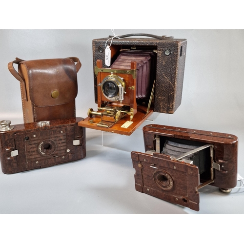 35 - An Eastman Kodak leather covered mahogany and lacquered brass bellows plate camera, together with tw... 