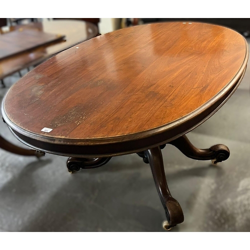 484 - Victorian mahogany tilt top centre table of oval form on quatrefoil scroll design base with casters.... 