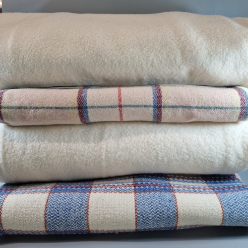 129 - Two similar multi-coloured checked Welsh blankets, together with two other plain cream blankets. (4)... 