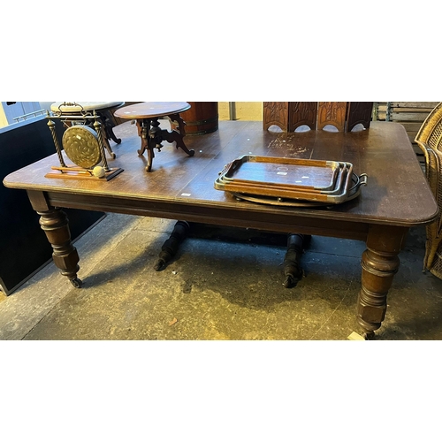 602 - Edwardian oak extending dining table, the moulded top on large baluster turned legs and casters, wit... 