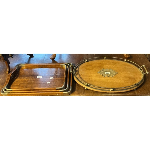 605 - Graduated set of oak and metal banded two handled trays, together with another late Victorian pale o... 