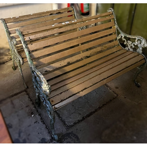 610 - Two similar metal framed garden benches, with scrollwork ends and wooden slats. 108cm wide and 110cm... 