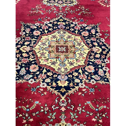 627 - Large Middle Eastern Mashad type carpet, on a red ground with central floral medallion and foliate a... 