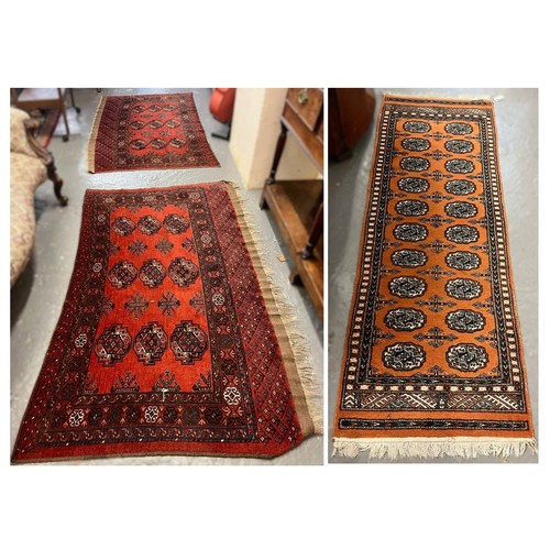 626 - Two vintage red ground Bokhara runners (probably originally one piece), together with another orange... 