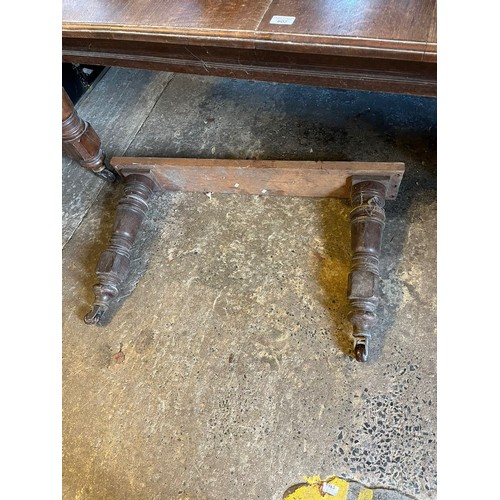 602 - Edwardian oak extending dining table, the moulded top on large baluster turned legs and casters, wit... 