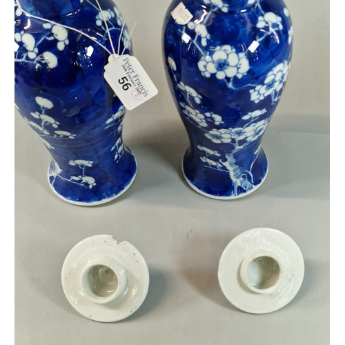 56 - A pair of export Chinese porcelain under glazed blue baluster shaped vases and covers decorated with... 