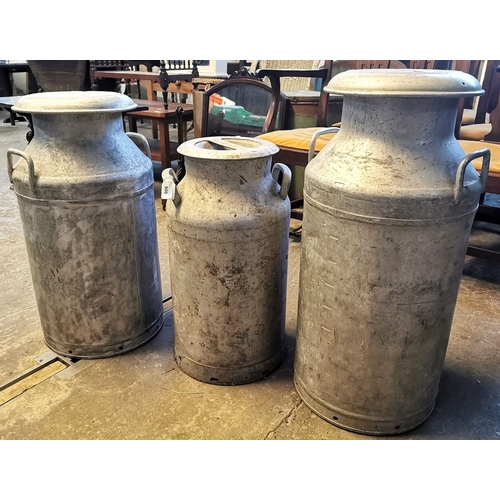 606 - Three vintage aluminium milk churns, Old Castle Farm Neath, Torrington and the other marked MMB (Mil... 