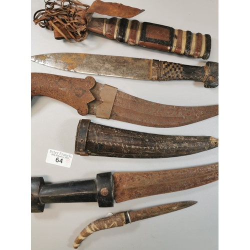 64 - Group of four Middle Eastern style daggers, two with sheaths. Distressed condition. (4) (B.P. 21% + ... 