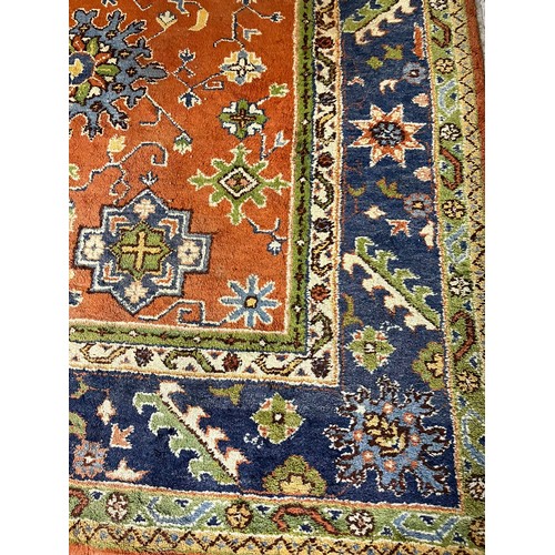 620 - Large Indian wool pile carpet with repeating medallions on a multi-coloured ground with stylised fol... 