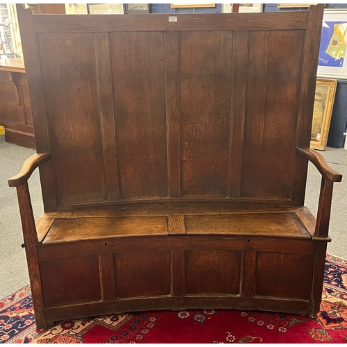 37 - Early 19th century Welsh oak settle, of curved back and front form, the high back with four rectangu... 