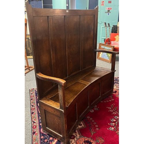 37 - Early 19th century Welsh oak settle, of curved back and front form, the high back with four rectangu... 