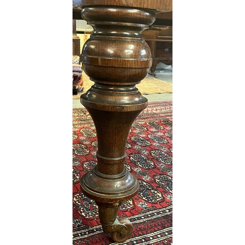 38 - Victorian oak extending dining table, the curved and moulded top above turned baluster legs, brass c... 